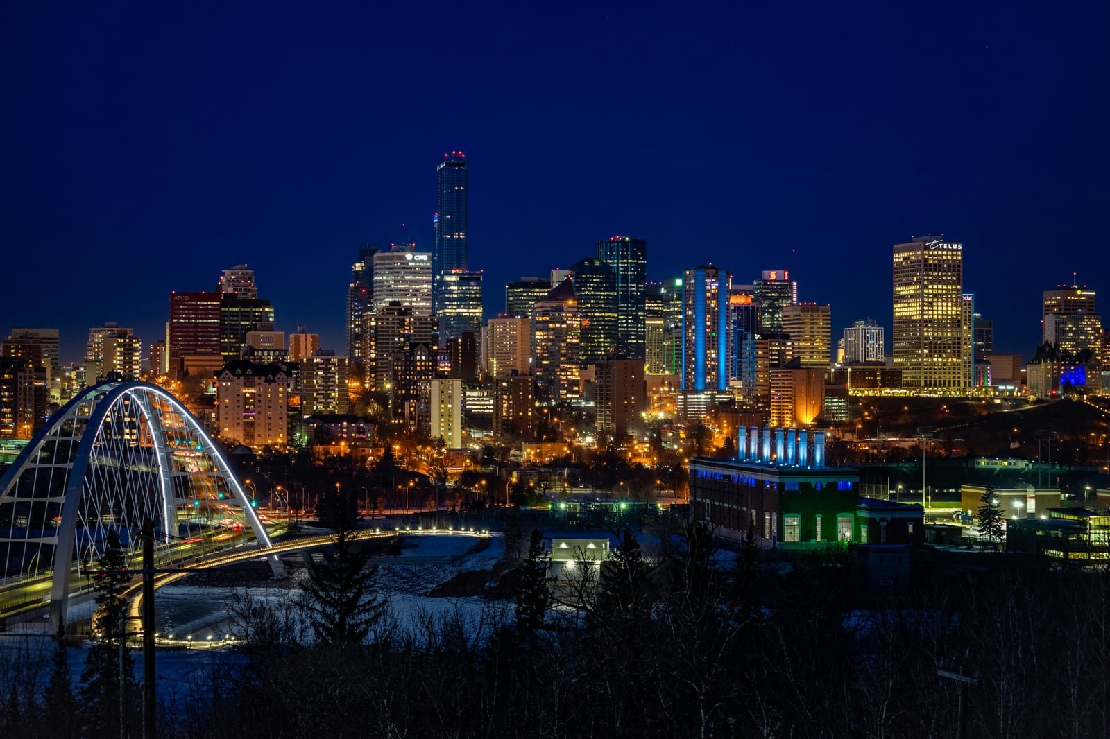 Edmonton’s illuminated downtown skyline and Walterdale Bridge at night.